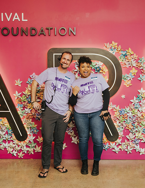 Two people in conversation at a creative event with VR headsets nearby